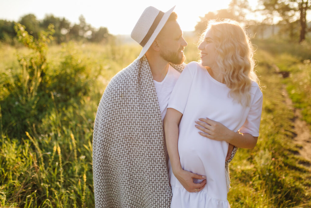 happy portrait of loving couple on a walk in the park on a sunny day.the woman is pregnant.
